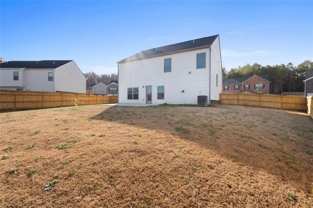 back of property with a lawn and central AC