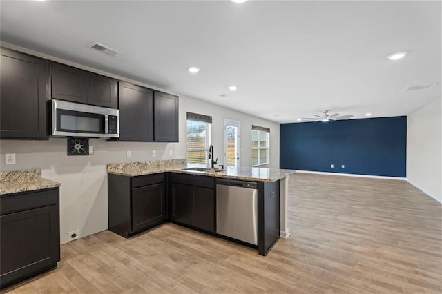 kitchen featuring sink, light hardwood / wood-style flooring, ceiling fan, appliances with stainless steel finishes, and kitchen peninsula