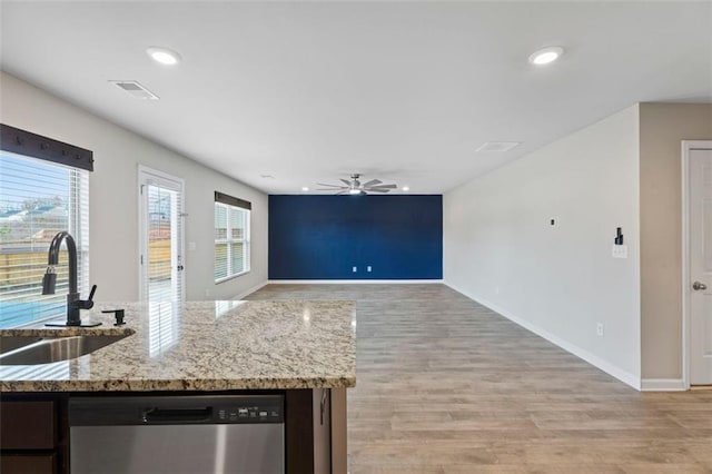 kitchen with dishwasher, sink, light hardwood / wood-style flooring, ceiling fan, and light stone counters