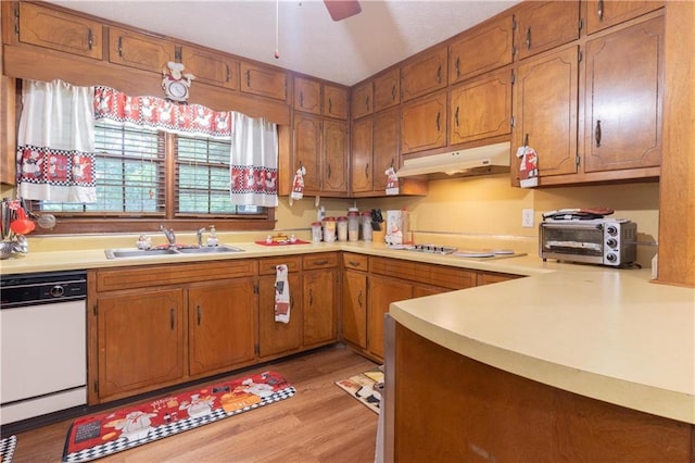 265 Forest Lake Dr, Covington, GA 30016 - kitchen featuring under cabinet range hood, white dishwasher, light countertops, light wood-style flooring, and brown cabinets