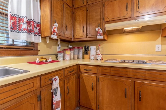 265 Forest Lake Dr, Covington, GA 30016 - kitchen with light countertops, brown cabinetry, and under cabinet range hood