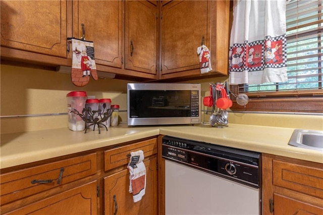 265 Forest Lake Dr, Covington, GA 30016 - kitchen featuring white dishwasher, stainless steel microwave, brown cabinets, and light countertops