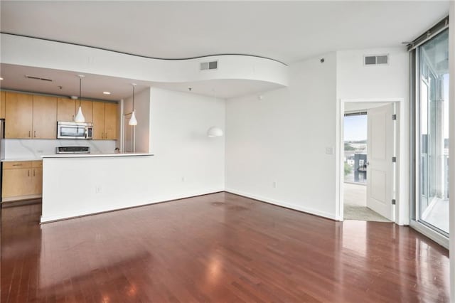 unfurnished living room featuring dark hardwood / wood-style flooring and floor to ceiling windows