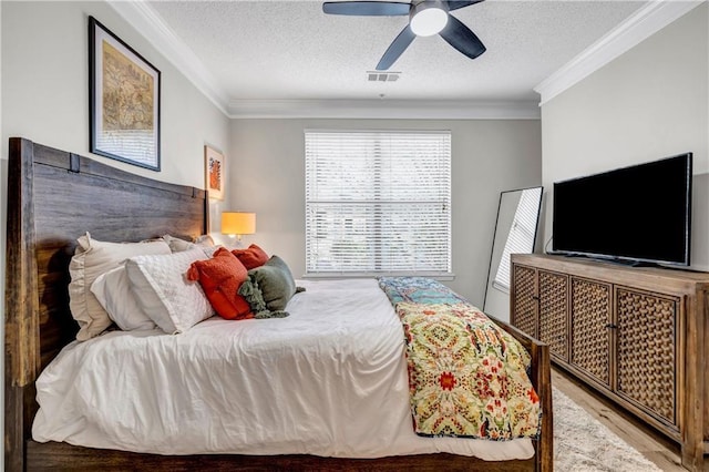 bedroom with hardwood / wood-style floors, crown molding, a textured ceiling, and ceiling fan