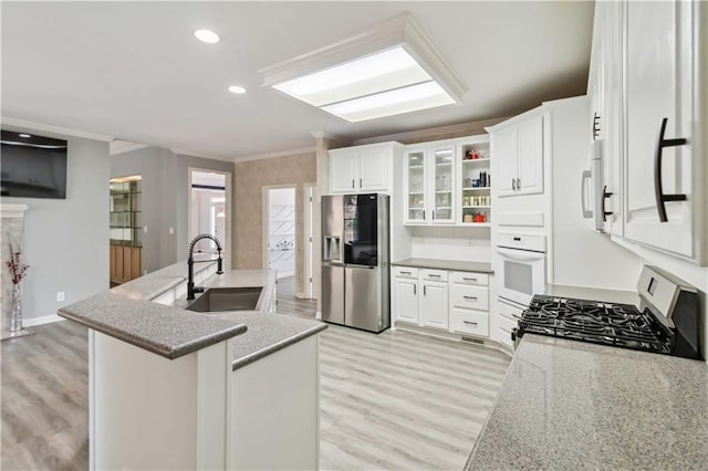 kitchen with crown molding, an island with sink, recessed lighting, white appliances, and a sink