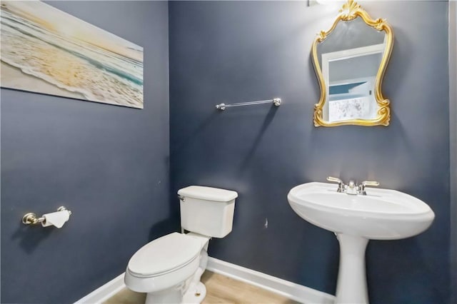 bathroom featuring baseboards and toilet