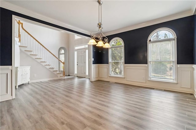 interior space with plenty of natural light, light wood-style flooring, and stairs