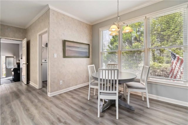 dining room featuring crown molding, wood finished floors, and baseboards