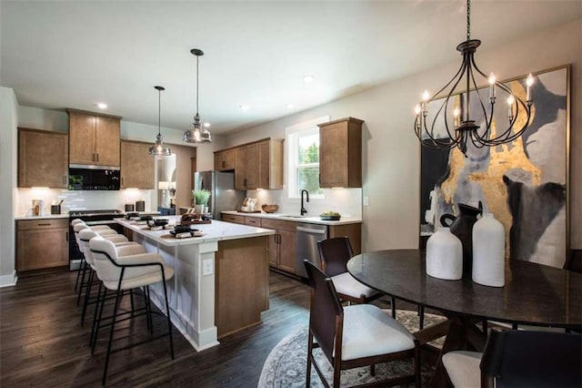 129 Henley St, Canton, GA 30114 - kitchen with stainless steel appliances, a kitchen island, light countertops, dark wood finished floors, and a chandelier