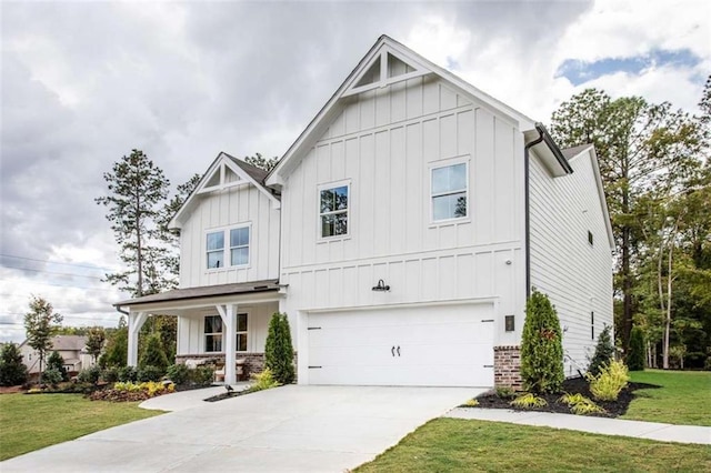 129 Henley St, Canton, GA 30114 - modern farmhouse featuring board and batten siding, an attached garage, a front lawn, and concrete driveway