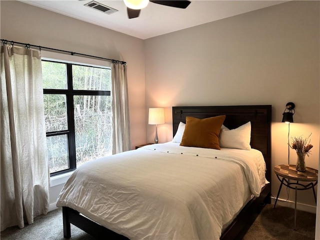carpeted bedroom with visible vents, baseboards, and ceiling fan