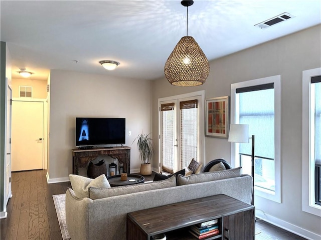 living area featuring a healthy amount of sunlight, baseboards, and visible vents