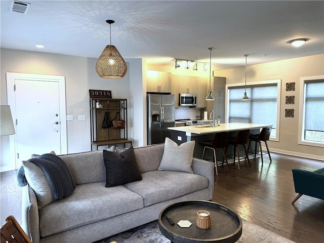 living room featuring rail lighting, visible vents, baseboards, and dark wood-style floors
