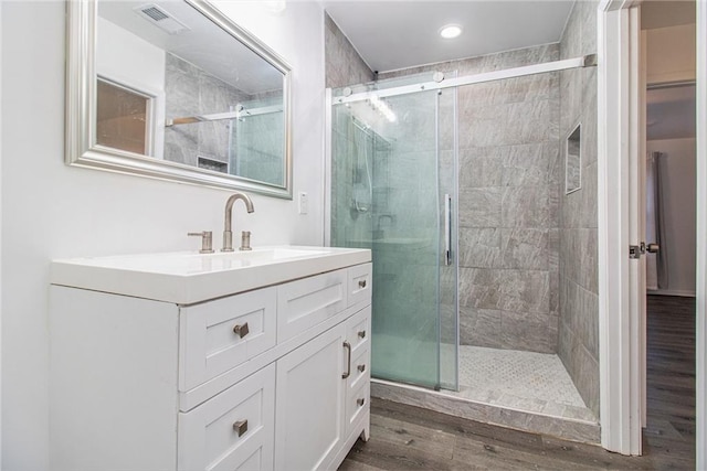 bathroom with a shower with door, vanity, and hardwood / wood-style floors