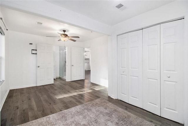 unfurnished bedroom featuring ceiling fan, dark hardwood / wood-style flooring, and a closet