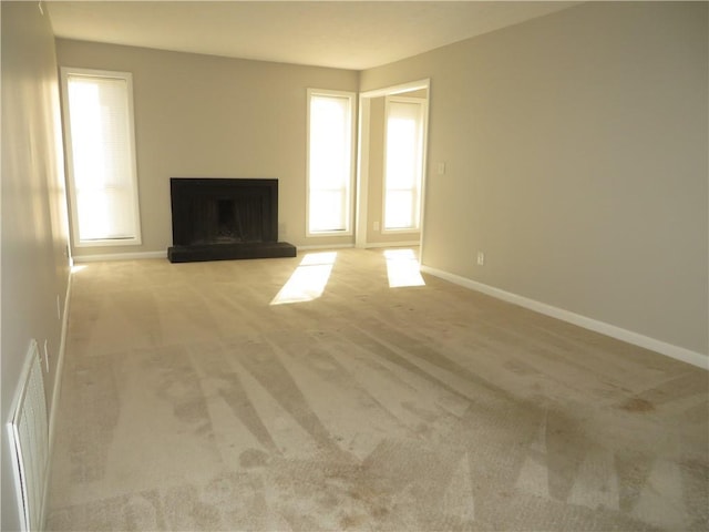 unfurnished living room featuring light carpet