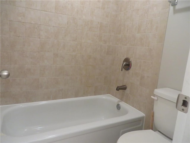 bathroom with tiled shower / bath combo and toilet