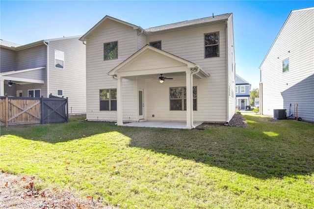 rear view of house with ceiling fan, a yard, cooling unit, and a patio