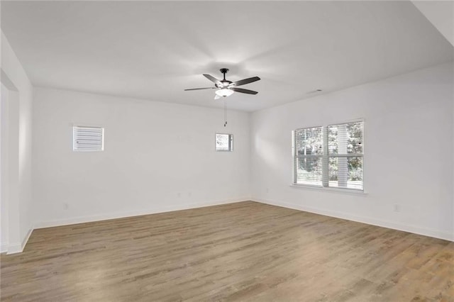 empty room with ceiling fan and light hardwood / wood-style flooring