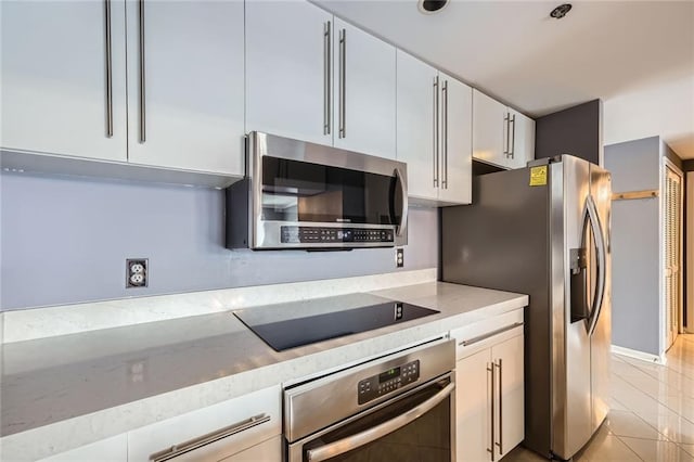 3481 Lakeside Dr NE Unit 1107, Atlanta, GA 30326 - kitchen featuring appliances with stainless steel finishes, light tile patterned flooring, white cabinets, and light stone countertops