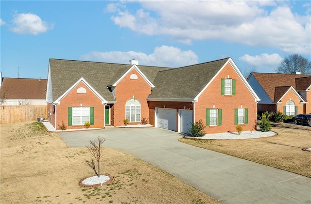 view of front of property featuring a garage, concrete driveway, a chimney, fence, and brick siding