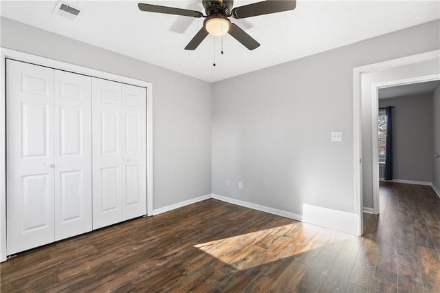 unfurnished bedroom with dark hardwood / wood-style floors, ceiling fan, and a closet