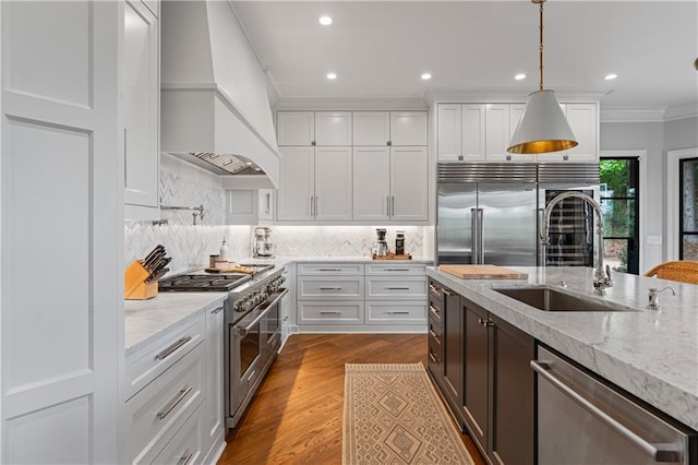 6515 Ashbourne Ct, Suwanee, GA 30024 - kitchen featuring premium appliances, a sink, premium range hood, ornamental molding, and white cabinets