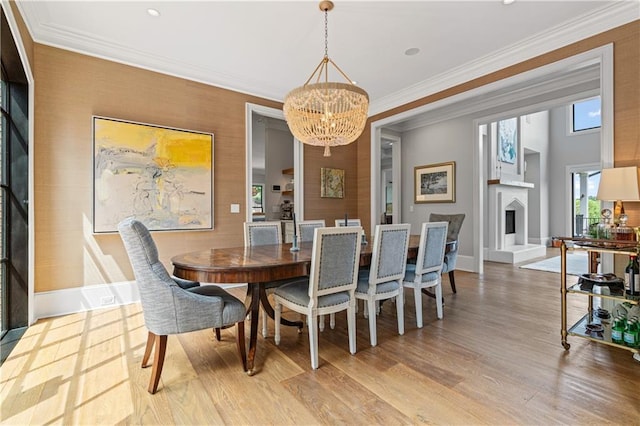 6515 Ashbourne Ct, Suwanee, GA 30024 - dining room featuring a chandelier, wood finished floors, baseboards, a fireplace with raised hearth, and crown molding