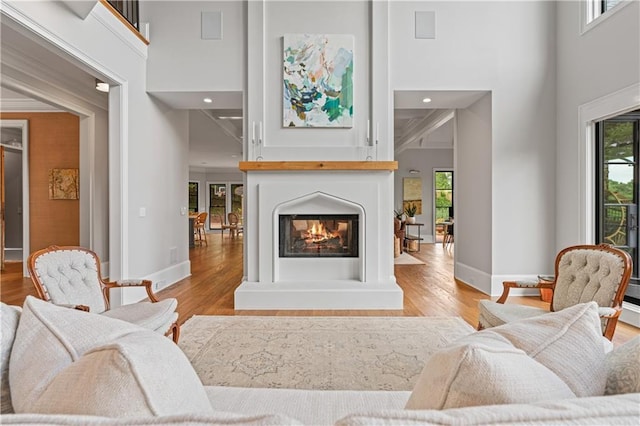 6515 Ashbourne Ct, Suwanee, GA 30024 - living room with wood finished floors, a high ceiling, baseboards, a multi sided fireplace, and recessed lighting