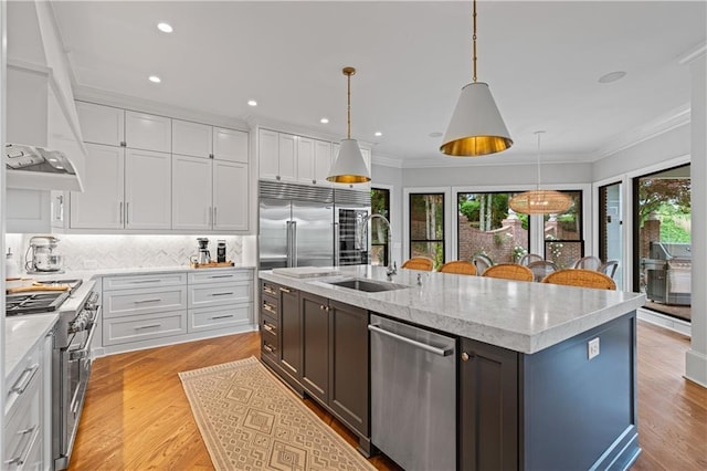 6515 Ashbourne Ct, Suwanee, GA 30024 - kitchen featuring high end appliances, a sink, plenty of natural light, white cabinets, and ornamental molding
