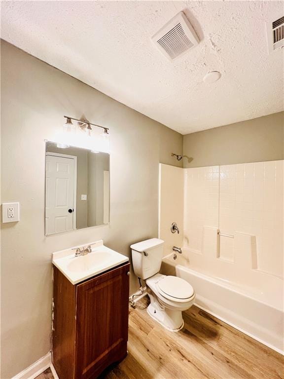 full bathroom featuring washtub / shower combination, toilet, a textured ceiling, vanity, and hardwood / wood-style floors