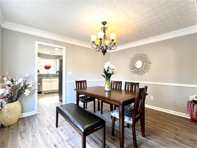 dining room with hardwood / wood-style flooring, ornamental molding, and a textured ceiling