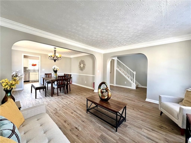 living room with hardwood / wood-style flooring, ornamental molding, and a textured ceiling