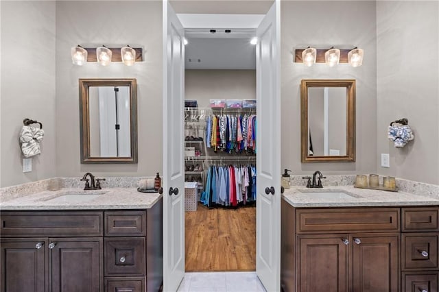 131 Quiet Cove Way, Monticello, GA 31064 - bathroom featuring two vanities, a walk in closet, and tile patterned floors