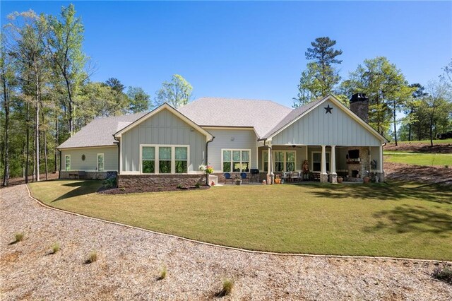 131 Quiet Cove Way, Monticello, GA 31064 - back of house featuring board and batten siding, a chimney, ceiling fan, and a yard