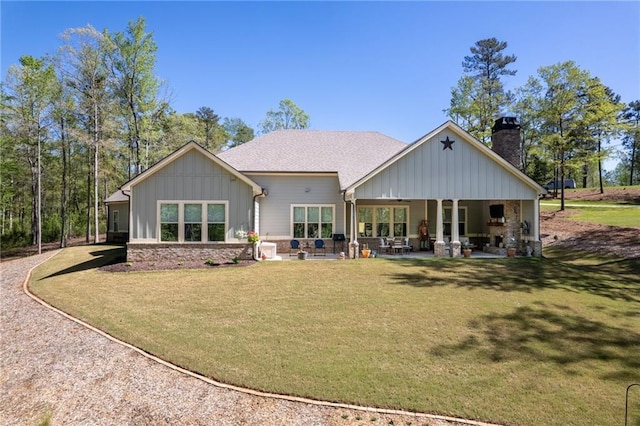131 Quiet Cove Way, Monticello, GA 31064 - back of property featuring board and batten siding, a chimney, a yard, and roof with shingles