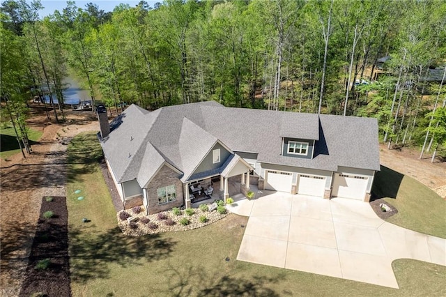 131 Quiet Cove Way, Monticello, GA 31064 - view of front of home featuring concrete driveway, a forest view, stone siding, and roof with shingles