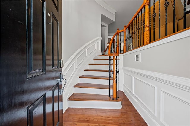 2873 Overlook Way NE, Atlanta, GA 30324 - staircase featuring a decorative wall, ornamental molding, wood finished floors, and a wainscoted wall