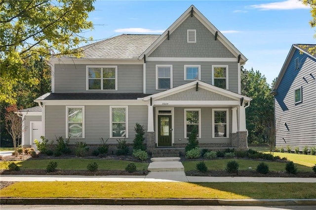 craftsman house featuring covered porch and a front lawn