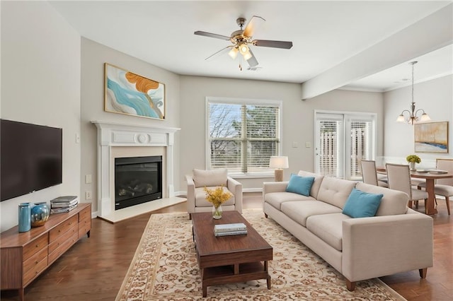 2785 Maple Park Pl, Cumming, GA 30041 - living room with visible vents, ceiling fan with notable chandelier, dark wood-style flooring, and a glass covered fireplace