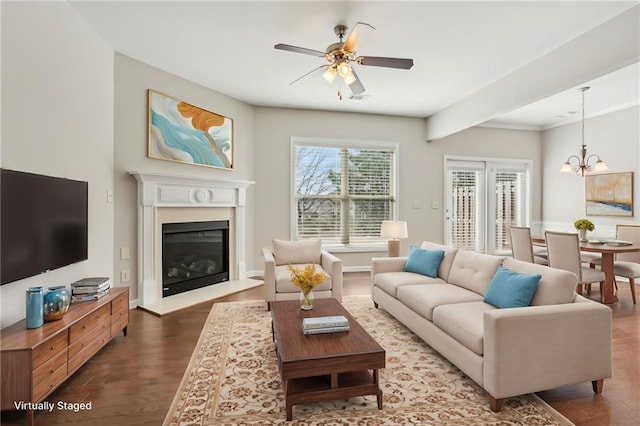 2785 Maple Park Pl, Cumming, GA 30041 - living area with dark wood-type flooring, a glass covered fireplace, visible vents, and ceiling fan with notable chandelier