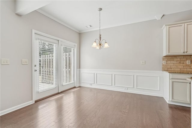 2785 Maple Park Pl, Cumming, GA 30041 - unfurnished dining area featuring a wainscoted wall, visible vents, a notable chandelier, and wood finished floors