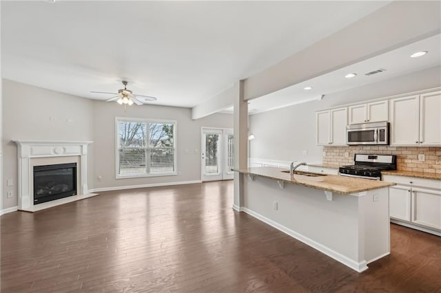 2785 Maple Park Pl, Cumming, GA 30041 - kitchen with dark wood finished floors, visible vents, backsplash, appliances with stainless steel finishes, and light stone countertops