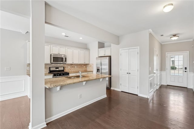 2785 Maple Park Pl, Cumming, GA 30041 - kitchen featuring dark wood finished floors, appliances with stainless steel finishes, light stone countertops, white cabinetry, and backsplash