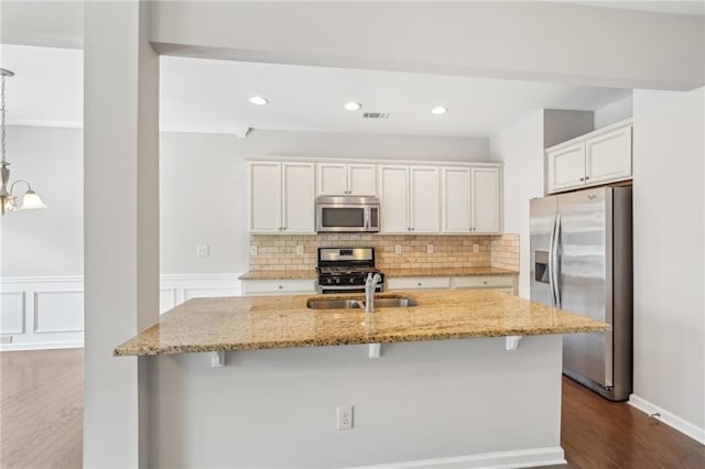 2785 Maple Park Pl, Cumming, GA 30041 - kitchen with stainless steel appliances, a sink, visible vents, light stone countertops, and tasteful backsplash