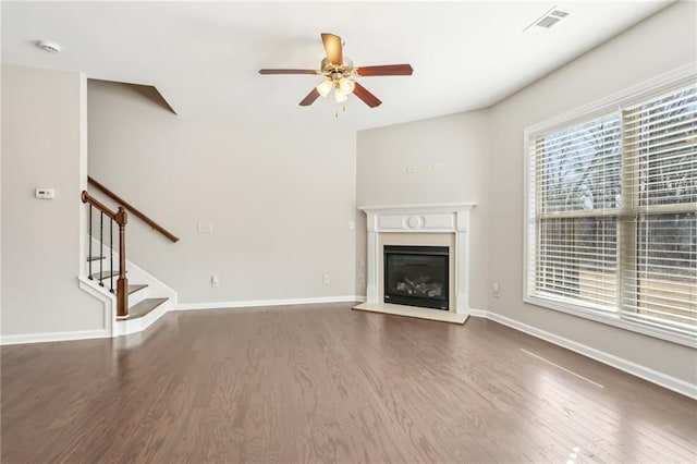 2785 Maple Park Pl, Cumming, GA 30041 - unfurnished living room featuring a glass covered fireplace, stairway, wood finished floors, and baseboards