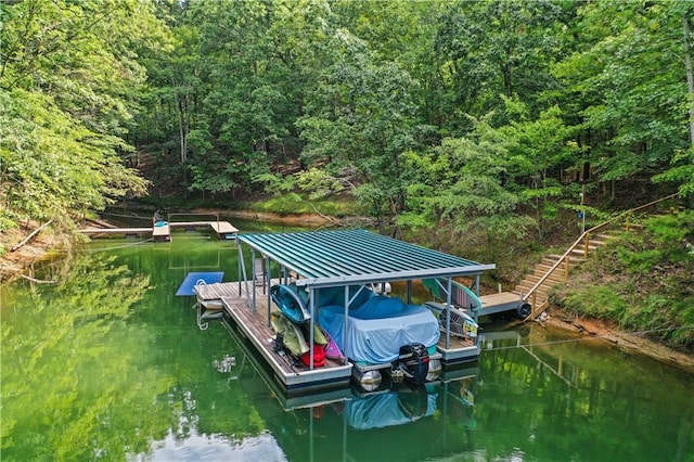 view of dock featuring a water view and a wooded view