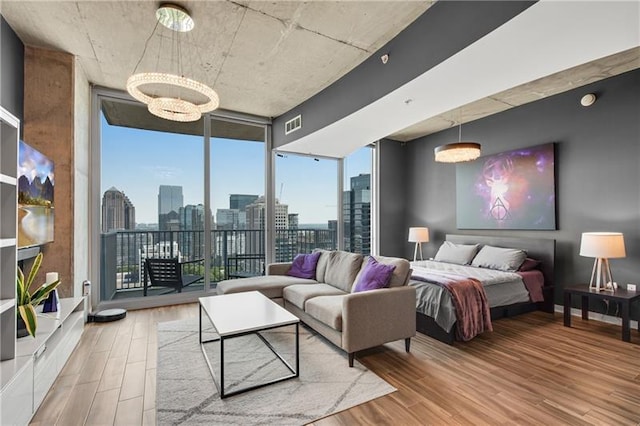 bedroom with floor to ceiling windows, hardwood / wood-style floors, and a notable chandelier