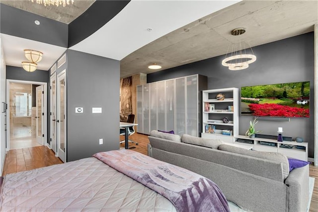 bedroom featuring a notable chandelier and light hardwood / wood-style flooring