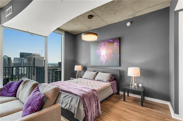 bedroom with hardwood / wood-style floors and floor to ceiling windows